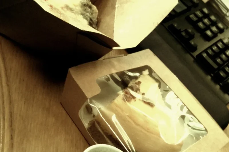 Bữa trưa văn phòng đặt cạnh bàn phím máy tính minh họa hiện tượng Food Coma và cơn buồn ngủ sau ăn của dân công sở