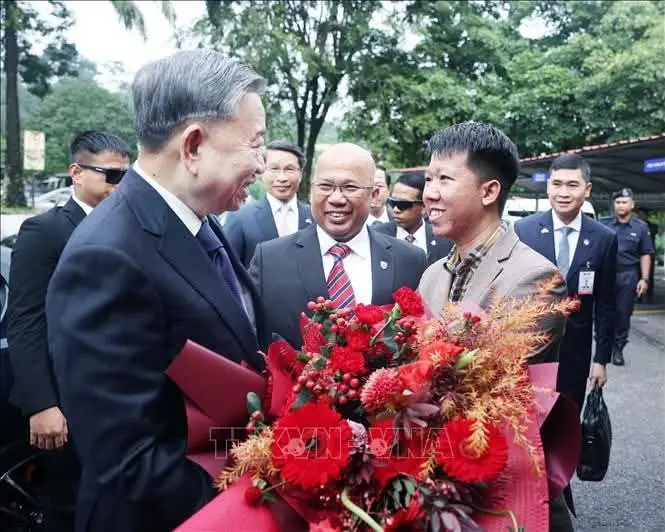 Dy Khoa presenting flowers to General Secretary To Lam at Universiti Malaya